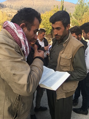 Giving Bibles to those who ask for one. The man in the background is the one who took Bibles for the school. 