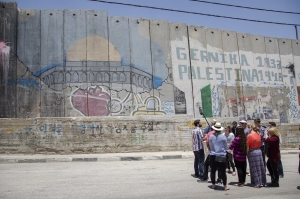 A Fatah representative addresses the group beside the security wall.